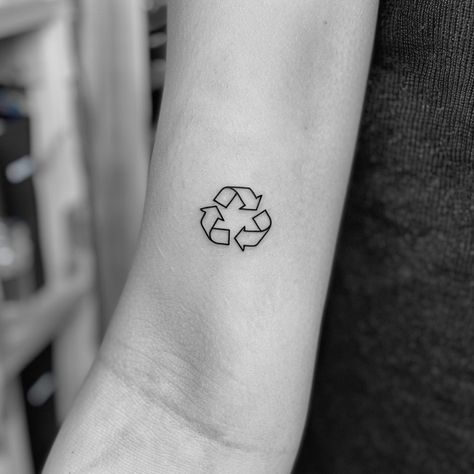 Embrace sustainability with a minimalist tattoo that makes a bold statement. This striking black ink symbol on the forearm, representing recycling, invites us all to commit to a greener planet. Let this be a reminder that every small action counts. Save for eco-inspiration and follow for more ways to live sustainably. #EcoTattoo #Sustainability #RecycleSymbol #MinimalistInk #GreenLiving #SaveThePlanet #EcoFriendly #AIimage Climate Tattoo, Environmentalist Tattoo, Sustainable Tattoo, Environment Tattoo, Recycle Tattoo, Earth Tattoo, Live Sustainably, Recycle Logo, Tattoo Concepts