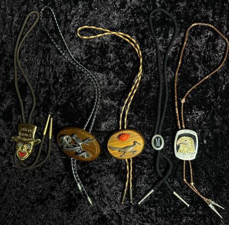 This unique lot of 5 vintage bolo ties offers a diverse collection sure to enhance any wardrobe. Included are two roadrunner-inspired bolo ties, one featuring a striking turquoise accent. Also in the set is a made-in-Germany eagle bolo tie, showcasing exquisite craftsmanship. The lot is rounded out with a 1970s goldstone joker bolo tie and a vintage monogrammed 'M' bolo tie, perfect for adding a touch of retro flair to any outfit. All bolo ties measure approximately 17.5 inches and are in different states of wear and condition. Bolo Tie Outfit, Montana Core, Cowboy Clown, 70s Cowboy, Clown Art, Tie Outfit, Bolo Ties, Sedona Az, Turquoise Accents