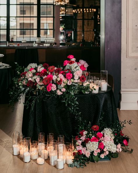 All eyes on the newlyweds and the sweetheart table that is decorated to their liking! 🩷 This HOT pink wedding was the hot topic among guests, wedding teams, and everyone who was WOW-ed by these beautiful pictures captured by @lovestruckpictures photographers! The centerpieces for this gorgeous sweetheart table at @cescaphe ‘s Swith House had a white base with many hot pink elements and touches of red. Sitting atop black tablecloths and situated beside the gentle glow of our candles, we were ... Black Tie Wedding With Color, Black Wedding Sweetheart Table, White And Black Sweetheart Table, Black And Pink Wedding Theme, Valentines Wedding Ideas, Hot Pink Wedding Theme, Dark Pink Wedding, Black Tablecloths, Pink And Black Wedding