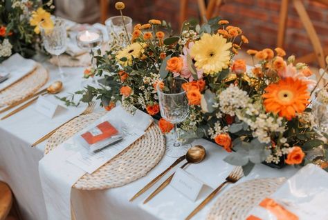 A retro 70's-esque wedding guest tablescape décor with autumnal tones. A rattan placemat, gold cutlery, tealight candles and a personalised menu. Beautified with a floral table centerpiece of gerberas, daisies, and eucalyptus leaves. Daisy Wedding Decorations, Daisy Wedding Centerpieces, Gerbera Wedding, Gerbera Daisy Wedding, Rattan Placemat, Gold Cutlery, Tealight Candles, Floral Table, Spring Theme