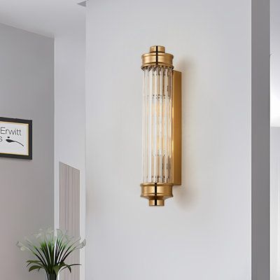 In the realm of postmodern wall lighting, the Nordic Ribbed Glass Wall Sconce stands as a testament to true elegance, blending simplicity with ancient/vintage allure. The tall, slim cylindrical shade of clear ribbed glass, supported by minimal hardware and a rectangular backplate, creates a 1-light sconce with a cool vintage look. | Mercer41 Sharima Ribbed Glass Rod Cylindrical Wall Light, 2 Heads Wall Lamp Wall Sconces Glass in Yellow | 16.7 H x 3.3 W x 3.3 D in | Wayfair Brass Bathroom Wall Lights, 1920s Bathroom Sconces, Wall Sconces Next To Tv, Bar Sconces, Bathroom Mirror Sconces, Powder Room Sconces, Vintage Bathroom Light Fixtures, Brass Sconces, Brass Wall Lamp