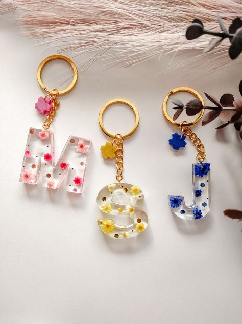 Colorful keychains with real dried flowers personalized with any letter you want 🤍 Resin Keychain Letters, Epoxy Resin Letter Keychain, Resin Keyrings, Letter Resin Keychain, Diy Resin Gifts, Resin Letter Keychain With Name, Resin Letter Key Rings, Resin Works, Letter Keychain