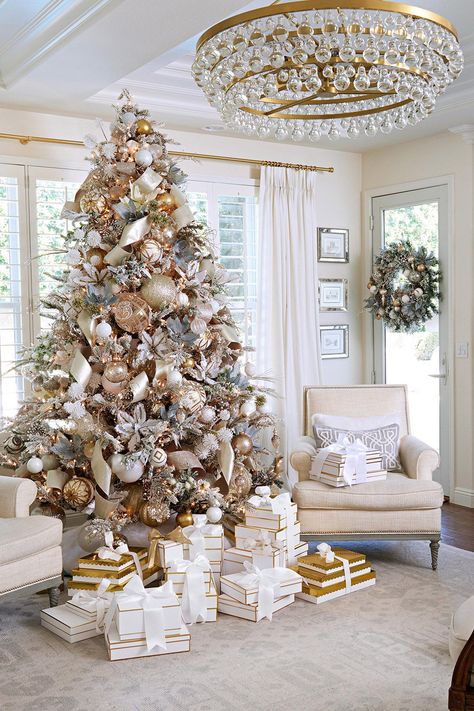 A soft flocked Christmas tree anchors this luxe holiday living room. Enhance it with faux flower blooms, ribbons, and loads of ornaments. Gift boxes, rather than paper wrappings, coordinate with the decor's color scheme. #livingroomdecor #christmaslivingroomdecor #holidaylivingroomdecor #christmasdecorideas #christmasdecorideasforlivingroom #bhg Joululahjat Diy, Holiday Living Room, Glam Christmas Decor, Christmas Tree Decorating Themes, Glam Christmas, Elegant Christmas Trees, Christmas Decor Inspiration, Gold Christmas Decorations, Christmas Tree Inspiration