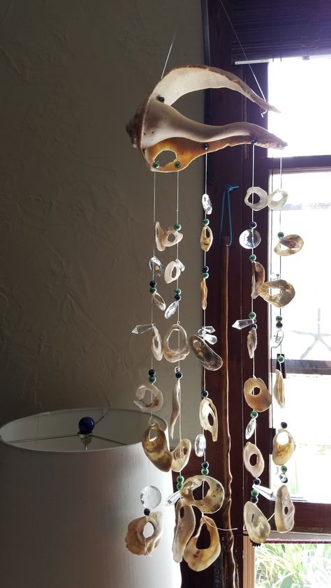 Handcrafted suncatcher or mobile.  Made with authentic shells from Assateague Island off the eastern coast of Maryland, or The Outer Banks N.C. The shells are artfully strung together with crystals and crystal beads, sometimes pearls hanging from a piece of driftwood found on the beaches right here in my community on the Chesapeake Bay, Md . Macrame With Shells Wall Hanging, Shell Windchimes Diy, Shell Mobile Diy, Driftwood Crystals, Things To Do With Shells, Things To Do With Sea Shells, Shell Suncatcher, Stone Mobile, Hanging Shells