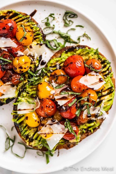 Enjoy this flavorful avocado tomato toast as a light meal, or slice it up and serve it as an appetizer. Grilled sourdough is topped with ripe avocado, sautéed cherry tomatoes, parmesan, and basil, then drizzled with balsamic glaze. It's easy to make and ready in just 10 minutes! #theendlessmeal #avocadotoast #toast #avocados Avocado Toast Balsamic Glaze, Gourmet Avocado Toast, Balsamic Avocado Toast, Avocado Toast With Balsamic Glaze, Avocado Toast With Egg And Tomato, Avocado Toast With Tomatoes, Cherry Tomato Toast, Avocado Tomato Toast, Vegan Avocado Toast