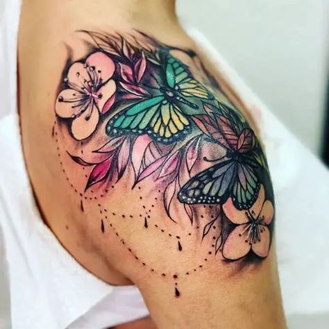 30+ Most Beautiful Flower Tattoo On Shoulder You'll Actually Want Forever Shoulder Female Tattoo, Shaded Shoulder Tattoos For Women, Shoulder Tattoo Butterfly Flowers, Floral Shoulder Tattoos For Women Color, Butterfly Tattoos For Women Shoulder, Female Shoulder Tattoo Ideas, Shoulder Cap Tattoos For Women Flower, Womans Shoulder Tattoo, Colored Shoulder Tattoos For Women