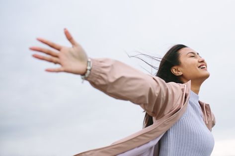 Portrait of a smiling woman standing outdoors with stretched arms on a cold winter morning. Side view close up of a happy woman standing outdoors with open arms and closed eyes. Cold Winter Morning, Arm Stretches, Your Twenties, Enjoying Nature, Smiling Woman, Happy Woman, Winter Morning, Body Reference Poses, Standing Poses