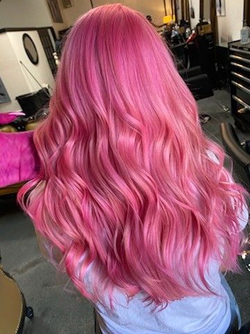 The back of a woman's head who has long (mid-back) bright pink hair.  It is curled and a stylist is holding a stand. Pink Hair Bubblegum, Bubblegum Hair Color, Pink Hair On Pale Skin, Pink Mermaid Hair, Barbiecore Hair, All Pink Hair, Pink Magenta Hair, Raspberry Pink Hair, Cherry Pink Hair