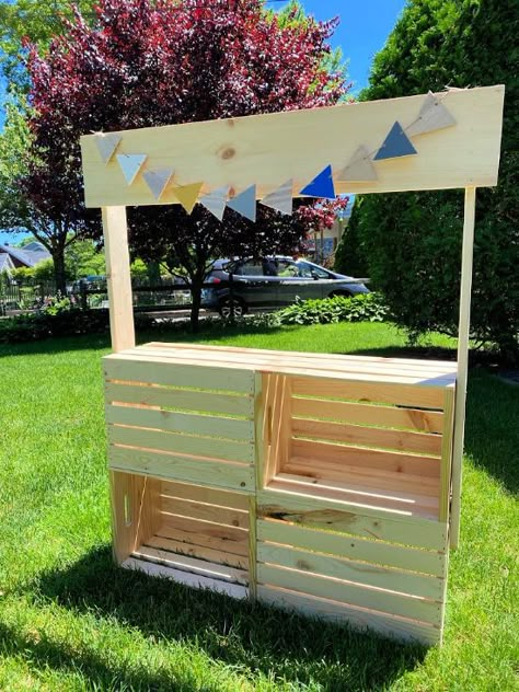 Use this easy to build crate stand for lemonade sales, farmer's market, or classroom dramatic play area. Homeroad.net #classroom #crates #lemonadestand #farmersmarket #dramaticplay #kids Wood Crate Lemonade Stand, Dramatic Play Market Stand, Build Your Own Lemonade Stand, Crate Stand Diy, Build A Lemonade Stand Easy Diy, Wooden Crate Lemonade Stand, Farmers Market Stand Diy, Wooden Lemonade Stand, Diy Farmers Market Stand Kids