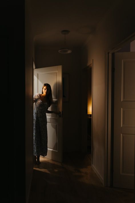 A woman is standing in a dark hallway photo – Free At home Image on Unsplash Night Photography At Home, Doorway Photoshoot, Hallway Poses, Photoshoot Inspiration At Home, Woman Opening Door, Home Photoshoot Woman, Hallway Photoshoot, Hallway Photography, Door Photoshoot