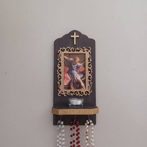 "Display your rosaries with our rosary holders! Each one is crafted by hand, and has a picture featuring a religious image. With this hanging on your wall, it will remind you to pray the rosary more often as well as conveniently store your rosaries without them tangling or getting lost. Details of the product: - Saint Michael image - 3 hooks for hanging rosaries - Approximately 13\" x 6\" x 3.25\" - Hooks on back for hanging (Other items not included)" Rosary Hanger, Rosary Holder, Divine Mercy Rosary, Rosary Boxes, Pray The Rosary, Praying The Rosary, Saint Michael, Religious Images, The Rosary