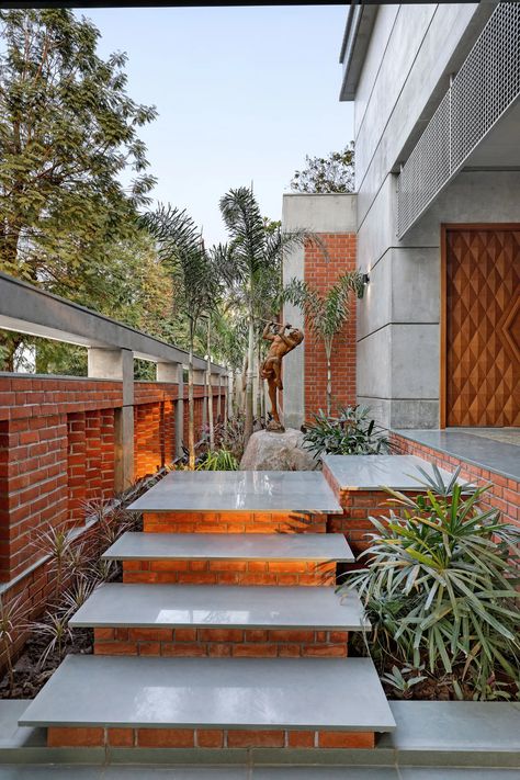 A three-level bungalow in Vadodara designed for a traditional Gujarati joint family | Architectural Digest India Bungalow Entrance Steps Design, Archdaily Interiors, Entrance Stairs, Villa Landscape, Normal House, Brick Cladding, Concrete Ceiling, Steps Design, Brick Architecture