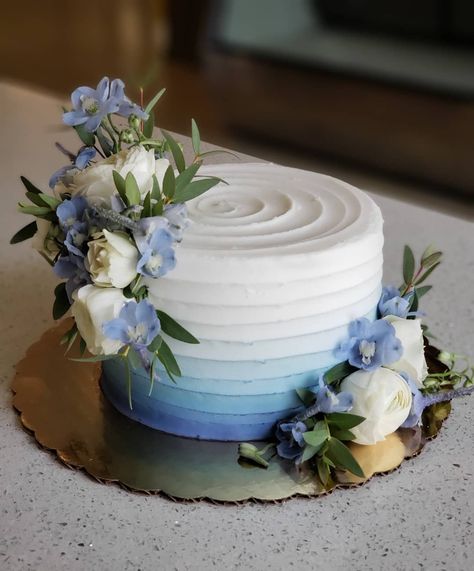 Soft blue ombre with fresh flowers to match 💙  #floralcake #weddingcake #cakedecorating #ombrecake #blueombre #weddingcakes… Blue Gradient Wedding Cake, White And Blue Engagement Cake, Blue Ombré Wedding Cake, Blue Cake Decorating Ideas, Single Tier Wedding Cake Blue, White Cake Blue Flowers, Small Blue Wedding Cake, 2 Tier Wedding Cakes Simple Elegant Blue, Small One Tier Wedding Cake