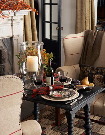 A romantic meal doesn't have to take place in the dining room. Put a small table next to a warm fire for an intimate dinner for two. Designer Ralph Lauren created this cozy table setting by adding a glowing candle and red flannel-patterned napkins. Click through for more fall home decorating ideas. Autumn Interior, Fall Table Decor, Fall Table, Favorite Kitchen, Ralph Lauren Home, Deco Table, A Fire, Autumn Home, Fall Home Decor