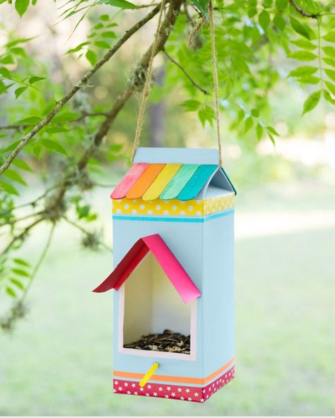 a milk carton decorated with paper washi tape and colorful popsicle sticks turned into a bird feeder hanging from a branch Milk Carton Bird Feeder, Roadside Stand, Bird Feeder Craft, Easy Bird, Diy Bird Feeder, Diy Birds, Milk Carton, Toddler Fun, Popsicle Sticks