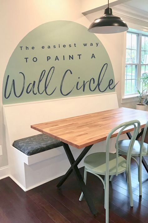 Green circle painted above a banquette bench behind a table. Painting Headboard Ideas On Wall, Circle Feature Wall Bedroom, Paint Half Circle On Wall, Half Moon Painted Wall, Painted Oval Accent Wall, Painted Half Circle Headboard, Painted Wall As Headboard, Boho Geometric Wall Paint, Oval Painted Wall