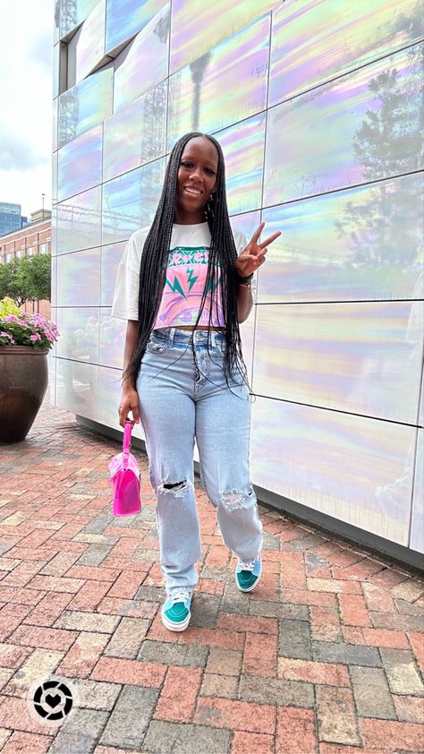 Black girl standing in front of a building with a white, green, and pink crop top graphic tee, light wash distressed mom jeans, holding a pink translucent purse, and wearing vans sk8 hi multicolored shoes Mom Jean Outfits Black Women, Graphic Tee And Jeans Outfit Black Women, Graphic Tees Outfit Black Women, Mom Jeans Outfit Black Women, Graphic Tee And Jeans Outfit, Lugged Converse Outfit, Graphic Tee Outfit Black Women, Outfits Graphic Tees, Affordable Outfits