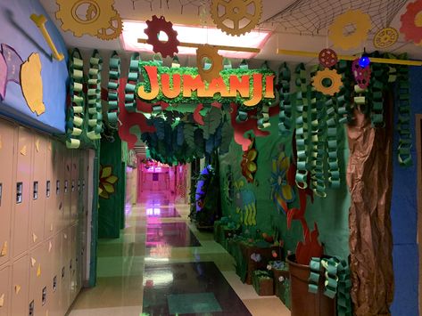 Hallway decorating for homecoming week. Contains: leaf chains, jumanji sign, barrel of monkeys, giant flowers, flower inserts, water fall, and a hippo. Jumanji Halloween Decorations, Jungle Theme Homecoming Float, Hallway Decorating Spirit Week, Homecoming Wall Decorations, Jumanji Float Ideas, Jumanji Classroom Theme, Jumanji Classroom Transformation, Jungle Hallway Theme, School Hallway Themes Ideas