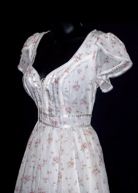 This is a vintage Gunne Sax dress from the 70s. It's made from a cotton blend material with pink roses and a white background. Its trimmed with lace, ribbon, and pearls. The inside is lined. The front laces up like a corset. The corset can be loosened slightly to add a little more room if needed. The bottom has a full skirt with an attached slip underneath. It zips and ties in the back. CONDITION: Great condition, no flaws found. New with tag. ESTIMATED SIZE: XS. The size tag is marked as a 7 in Short Gunne Sax Dress, Floral Coquette Dress, Gunne Sax Prom Dress, Prarie Dresses 70s, Cottagecore Closet, Gunne Sax Dress Vintage 70s, Cotton Wedding Dress, Southern Dress, 1960s Clothing