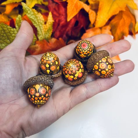 This listing is for a set of five (5) hand painted large (2) and jumbo (3) acorns in yellow, orange, salmon pink and metallic gold. Your set will be chosen at random and will contain one of each pattern pictured.  The acorns were collected in the Outaouais region of Quebec, Canada, dried, washed, baked, painted , and then sealed with satin varnish for protection.  The large acorns measure approximately: . 75 inches wide x 1 inch tall (not including stem) The jumbo acorns measure approximately: Acorn Painting Preschool, Acorn Painting Ideas, Crafts Using Acorns, Things To Do With Acorns, Painted Acorns Ideas, Painting Acorns, Dot Art Patterns, Acorns Crafts, Nut Crafts