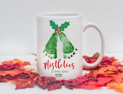 "Custom Christmas Mistletoes footprints mug is perfect for a mom, dad, grandparents, aunts, uncles or any family member!  Our coffee mugs make the perfect gift for Mother's and Father's Day, Valentine's Day, Christmas, Birthdays, Anniversaries, Retirement Parties, Boss's Day, Graduations...or just for the fun of it! SEND US YOUR FOOT PRINT IMAGE:  Please include the name and date you would like on the mug in the personalization box.  The image will be put on both sides of the mug so if you have Baby Handprint Mugs, Handprint Coffee Mug Diy Christmas, Footprint Mug, Handprint Mugs Christmas, Xmas Gifts For Grandparents, Handprint Coffee Mug, Handprint Pottery, Mistletoe Footprint, Diy Christmas Mugs