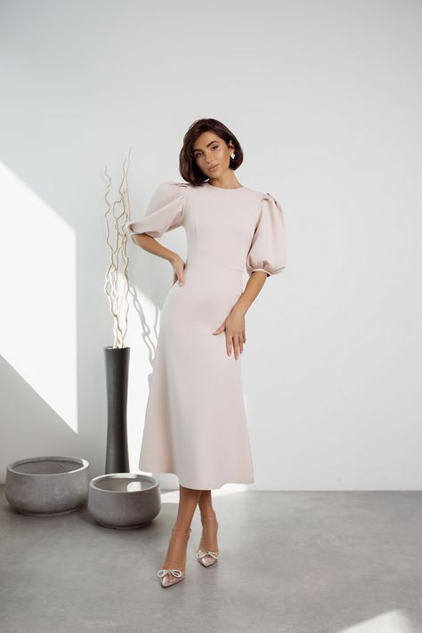 Elevate your style with our Beige Puff Sleeve Midi Dress. The soft and neutral beige hue exudes understated elegance, making it a versatile choice for various occasions. The puff sleeves add a touch of drama and femininity to the classic midi length, ensuring you'll look effortlessly chic and sophisticated. #beigedress #puffsleeve #dress #dresses #mididress #stylish #elegant #eveningwear #eveningdress #partydress #promdress #dresslover #weddingdress #fashion Cream Dresses Classy, Puff Sleeve Long Dress, Puff Sleeve Dress Classy, Cream Dress Outfit Classy, Classy Prom Dresses Elegant, Elegant Midi Dress Classy, Champaign Dress, Cream Dress Outfit, Dress Elegant Classy