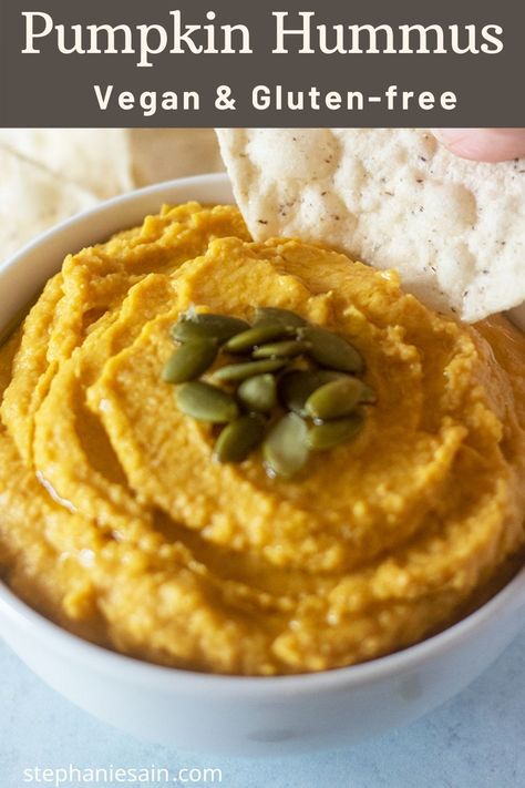 pumpkin hummus in a white bowl garnished with pumpkin seeds and tortilla chips by the bowl for serving. A hand dipping into the pumpkin hummus with a chip. Pumpkin Recipes Side Dish, Pumpkin Recipes Savory, Pumpkin Hummus Recipe, Classic Hummus Recipe, Last Minute Appetizer, Classic Hummus, Dairy Free Appetizers, Savory Pumpkin, Hummus Recipe Homemade