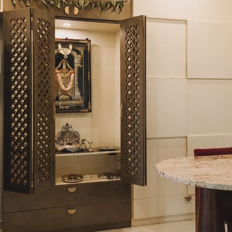 Small space mandir,dining area and crockery design! This mandir design fits perfectly in compact spaces, with a clever camouflaged cabinet that stores crockery out of sight. The folding door keeps the passage clear, and there’s even a cozy table for four. #smallspacesolutions #mandirdesign #space-saving #homedecor #interiordesign #compactliving [efficient design , small space interiors , mandir design , space saving hacks ] Compact Mandir Designs, Mandir Cabinet Design, Mandir Cabinet, Mandir Design Small, Small Mandir, Table For Four, Cozy Table, Crockery Design, Space Saving Hacks