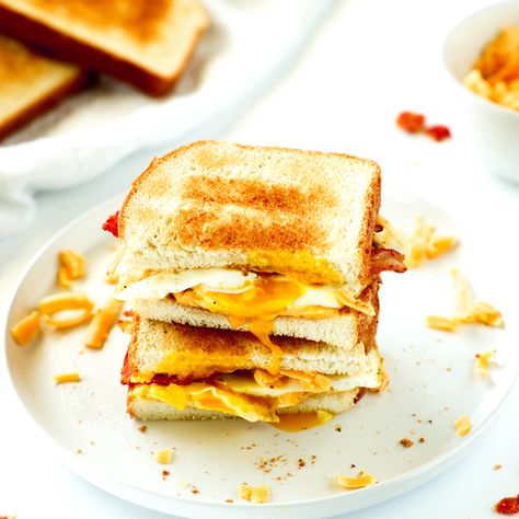 Two halves of an Egg Sandwich stacked on top of each other with a bowl of grated cheese and some more toast sitting behind them. Fried Egg Sandwich Recipe, Wholesome Breakfast Ideas, Frying Recipes, Egg Sandwich Recipe, Fried Egg Sandwich, Egg Sandwich, Egg Sandwiches, Breakfast Idea, American Cheese