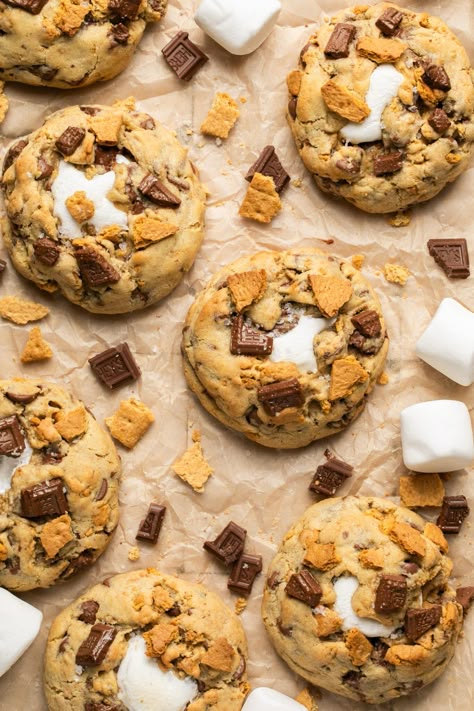 These S'mores Cookies have a gooey, melty, marshmallow center, filled with graham crackers and generous chunks of Hershey chocolate throughout. They are thick, soft, and gooey on the inside but slightly crisp and golden brown on the outside. It's nostalgia in cookie form! #marshmallows #smorescookies #hersheys #chocolate #cookies #baking Smores Cookies With Marshmallow Fluff, S'mores Chocolate Chip Cookies, S’mores Stuffed Cookies, Must Make Christmas Cookies, Blueberry Cobbler Cookies, Crumb Cookie Recipe, S'mores Brownies, Aesthetic Cookie Pictures, S'mores Cookies