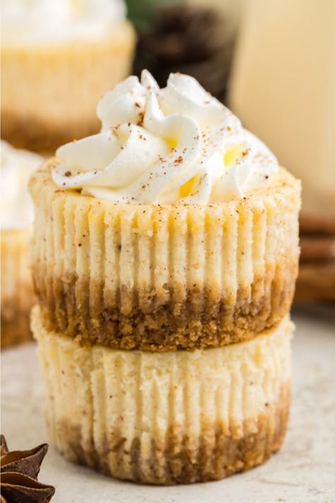 These Mini Eggnog Cheesecakes are a festive twist on classic cheesecake. Creamy, dreamy, and perfect for all your holiday celebrations. Mini Eggnog Santa Cheesecakes, Eggnog Cheesecake Bites, Mini Eggnog Cheesecake Recipe, Christmas Cheesecake Cupcakes, Eggnog Cheesecake With Gingersnap Crust, Best Christmas Cheesecake Recipes, Baking With Eggnog, Cheesecake Recipes For Christmas, Mini Christmas Cheesecake Recipes