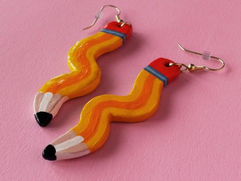 "This cute and bold pair of earrings features a pair of pencils! Each set is handmade and individually hand-painted with love, so they each have their own little groove!  These pencils are 2.6\" x 0.5\", and come with gold-plated stainless steel hooks! Each unique pair is sealed with a glossy polycrylic finish." Silly Clay Earrings, Polymer Clay Gift Ideas For Men, Unique Clay Earring Ideas, Clay Earrings Idea, Hand Made Earings, Easy Polymer Clay Earrings, Clay Earring Ideas, Painting Earrings, Funky Aesthetic