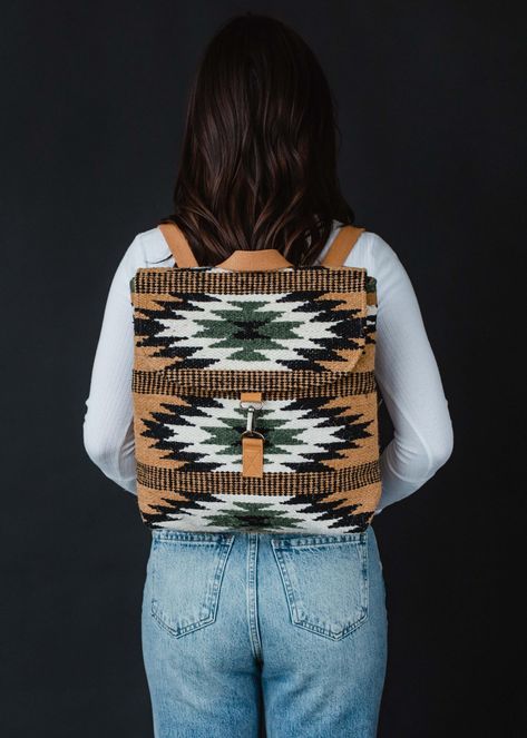 Stay organized and fashionable with our new Aztec inspired backpack. This brown, black, green and cream Aztec inspired backpack is a must have for the fall season ahead.  Brown, black, green and cream Aztec inspired backpack Clasp closure on the front  Adjustable straps and handle Measures 12" x 5" x 13" Designed in the U.S.A. Produced in India.  100% Cotton Lining: 100% Polyester Country Backpacks, Western School Backpacks, Western Backpack, Hooey Backpack, Fall Backpack, Aztec Backpack, Aztec Bag, Knit Hat For Men, Knitted Hats Kids