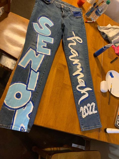 15 Cutest Senior Jeans Ideas We're Obsessing Over Right Now Senior Jeans Ideas, Senior Jeans Ideas High Schools, Homecoming Jeans Ideas, School Spirit Outfit, Senior Painted Jeans, Senior Year Diy, Senior Year Things, Senior Week, Senior Jeans