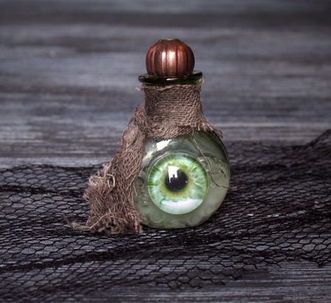 The creepy miniature bottle in dollhouse scale 1:12 is a great eyecatcher for Halloween. The small bottle is made of green glass, and filled with a magical tincture. The front of the bottle is dekorated with a glass pupil. The bottle-neck is adorned with a rag scarf. The bottle is closed with a bronze bead. Measurements: Height: 3.1 cm / 1.22 inch Width: 2 cm / 0.79 inch Depth: 1 cm / 0.39 inch IMPORTANT: The prise is for the bottle only. I added the owls for illustration only. Attention: This a Spell Bottles Diy, Scary Halloween Crafts, Halloween Potion Bottles, Halloween Apothecary, Empty Perfume Bottles, Magic Bottles, Halloween Potions, Witch Diy, Halloween Miniatures