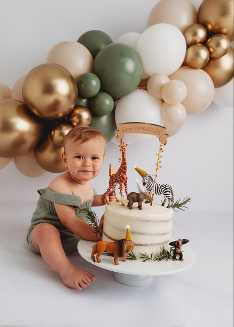 Alt=“baby boys first birthday cake smash eating cake of spoon wearing green romper”> 1st Birthday Photoshoot Wild One, Animal Cake 1st Birthday, Safari One Year Old Birthday Photoshoot, Cake Smash Safari Theme, Neutral Jungle Birthday Party, Safari 1st Birthday Photoshoot, Jungle Safari First Birthday, Natural Cake Smash, Wild One Cake Smash Photo Shoot