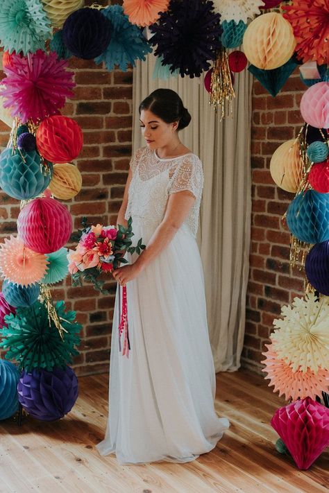 This styled shoot was an explosion of colour with a backdrop of a rainbow wedding arch made from paper honeycombs and pinwheels. Click through for more colourful wedding inspiration. #colourfulweddings #weddingideas #weddinginspiration #rainbowwedding #handmadeweddings #rachelemmastudio #paperflowers #weddingbackdrop Wedding Arch Alternative, Wedding Origami, Pinwheel Wedding, Origami Wedding Invitations, Handmade Wedding Decorations, Paper Pinwheels, Diy Wedding Arch, Origami Wedding, Colourful Wedding