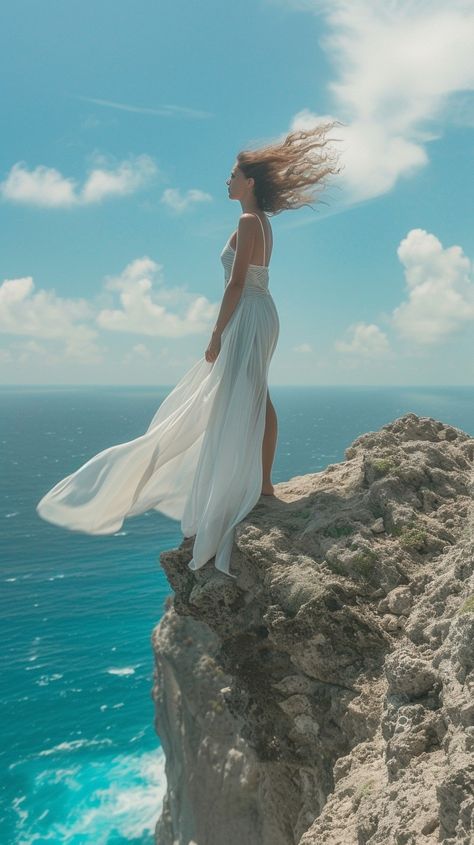 Elegant Cliffside Pose: A woman in a flowing white dress stands poised on a cliff overlooking the vast ocean. #woman #cliff #ocean #elegance #breeze #aiart #aiphoto #stockcake ⬇️ Download and 📝 Prompt 👉 https://ayr.app/l/fJRd Someone Falling Off A Cliff, Photo With Dress Aesthetic, Woman Figure Reference Drawing Poses, Girl Falling Off Cliff, Beach Cliff Photoshoot, Flowing Dress Photography, Dress Flowing In The Wind, Cliff Pictures, Cliff Photoshoot