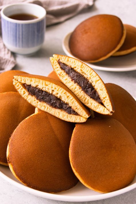 Learn how to make traditional Japanese Dorayaki (red bean pancakes. Make soft and fluffy honey pancakes with a sweet red bean filling. Japanese red bean pancake is very easy to make and involves a simple pancake batter. Japanese pancakes are small and round, typically no larger than the average doughnut. Like regular pancakes, dorayaki is made with common pancake ingredients but honey and mirin gives dorayaki its earthy, marshmallowy flavour and moistness. #dorayaki |www.foodelicacy.com How To Make Dorayaki, Japanese Dorayaki, Dorayaki Pancake, Soft Pancakes, Dorayaki Recipe, Easy Pancake Batter, Bean Pancakes, Pancake Ingredients, Simple Pancake