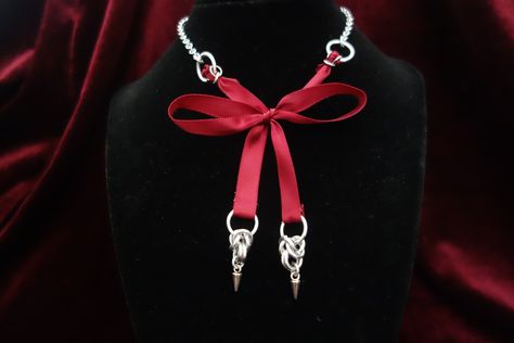 Handmade necklace featuring a red satin ribbon bow with hanging chainmail ornaments. The chainmail part features a spike charm at the end. The bow is adjustable but delicate. A perfect mix between coquette and alternative styles. Chainmail Ornaments, Ribbon Necklace Diy, Chainmail Necklace, Chainmail Jewelry, Spike Necklace, Alternative Jewelry, Satin Ribbon Bow, Ribbon Necklace, Goth Jewelry