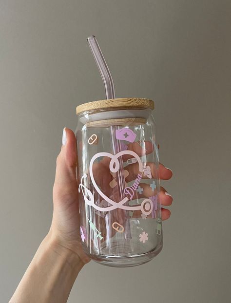 Custom Nurse Appreciation Libbey Glass with Bamboo Lid and Pink Straw  What does every nurse need to do their job?? An adorable personalized glass to keep their nurse fuel in!! ️ As a nurse that's constantly on the move, they don't have time to enjoy their coffee hot, so iced coffee it is! 👏🏼 This cute and trendy glass makes for a great gift for that special someone, friend, coworker, or even your favorite nurse! Fill it up with some chocolate or candy, and it is ready to be given as a lovely Personalized Nurse Gifts, Nurse Glass Cup, Nurse Glass Cup Ideas, Libbey Glasses Ideas, Nurse Cups, Personalized Cups Diy, Tumbler Cricut, Glass Tumbler With Straw, Glass Tumbler Design