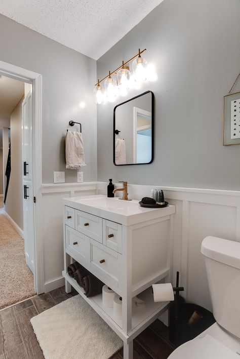 Half Bath With White Vanity, Half Bath With No Window, White Bath Vanity, White Bathroom Board And Batten, White Vanity Half Bath, Black Bathroom With White Wainscotting, Small Bathroom White Vanity, Half Bathroom With Wainscoting, Half Bathroom Wood Floor