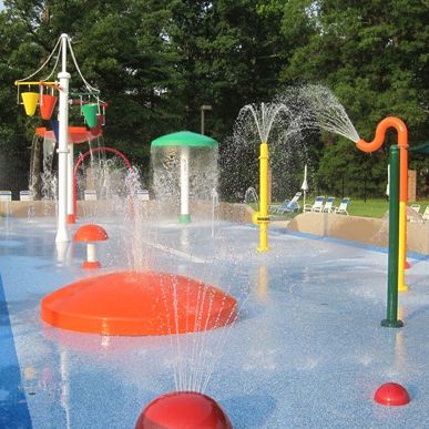 Thinking about making your facility more family friendly for the summer? Try incorporating a splash pad! A splash pad is a great addition to any facility looking to be more competitive with other summer attractions. #americanpool #pools #splashpad #summerattractions #familyfun #poolrenovations #summerfun #activitiesforkids #spraypads #waterplay Backyard Splash Pad, Backyard Water Parks, Spray Park, Park Ideas, Play Structures, Water Playground, Playground Ideas, Splash Park, Children Park