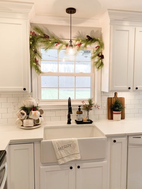 Kitchen Window Holiday Decor, Above Sink Christmas Decor, Garland Above Kitchen Sink, Christmas Kitchen Window Sill, Garland Over Kitchen Sink, Kitchen Sink Wreath, Christmas Decor Around Windows, Top Of Cabinet Decor Kitchen Christmas, Above The Sink Christmas Decor