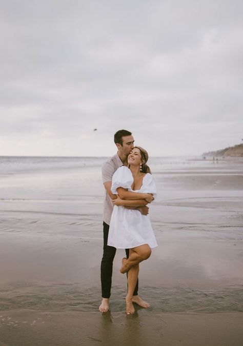 Cute Engagement Pictures Beach, Couple Beach Pictures Outfits Engagement Photos, Blue Dress Beach Photoshoot, Beach Dress Engagement Photos, Cloudy Beach Engagement Photos, Engagement Session Outfits Beach, Engagement Pictures At The Beach, Engagement Shoot Dress Beach, White Dress Beach Engagement Pictures