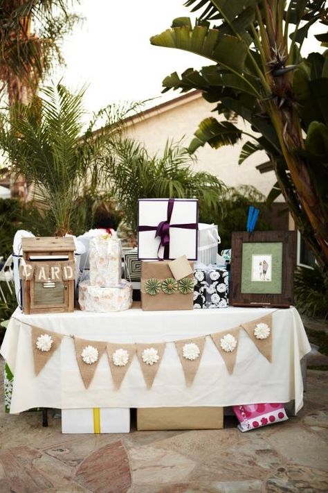 gift table with banner, pom poms hanging above and chalk board that says 'o you shouldn't have' Table With Gifts, Gift Table Set Up, Display Shower Gift Table Cute Ideas, Gift Table Ideas Graduation, Boho Gift Table Ideas, Party Gift Table Ideas, Presents Table Wedding, Gifts And Card Table Wedding, Gift Table Birthday Party