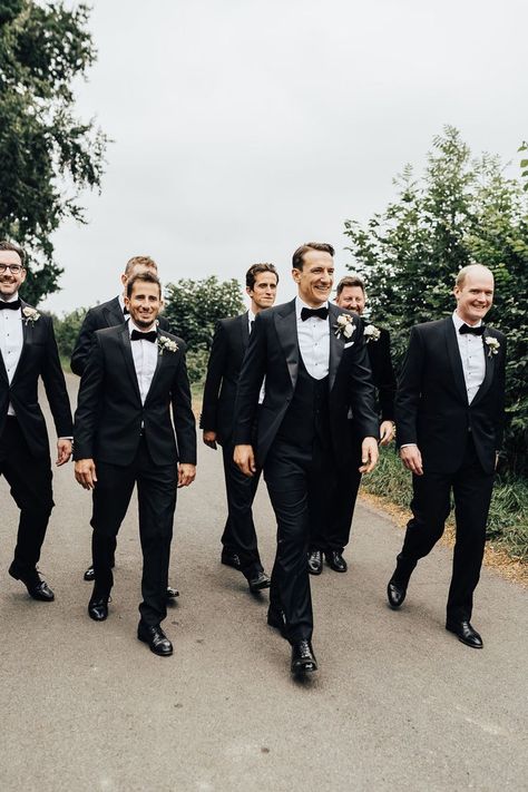 Groom and groomsmen in black tie and floral buttonholes walk down road. Black Tie Groom And Groomsmen, Green Satin Bridesmaid, Groomsmen Attire Black, Green Satin Bridesmaid Dresses, Sperry Tent Wedding, Black Tie Wedding Guest, Sperry Tent, Black Tie Wedding Guest Dress, Wedding Groomsmen Attire