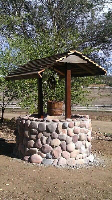 A Do-It-Yourself garden stone wishing well brings many decorative possibilities. Useful for creating a koi pond, a flower well, or tool shed. How To Build A Stone Wishing Well, Rock Wishing Well, Wooden Well With Flowers, Well Decoration Ideas, Water Well Design, Well Design Ideas, Wishing Well Diy, Stone Wishing Well, Water Well House