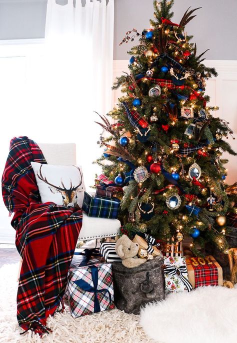 Patterns of plaid and tartan cover this tree, and are complemented by bright red and blue ornaments. Deer Party, Blue Christmas Decor, Plaid Christmas Decor, Tartan Christmas, Plaid Christmas Tree, Gold Christmas Decorations, Present Christmas, Unique Christmas Trees, Cool Christmas Trees