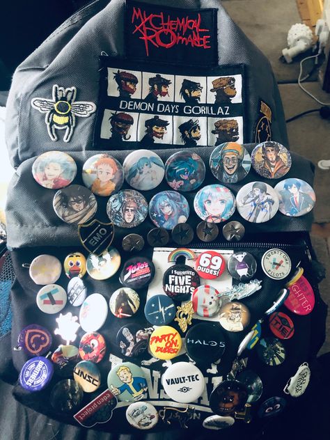 Grey bag covered in badges and pins from varying shows and music artists Badges On Backpacks, Messenger Bag With Pins, Pins On Bag, Bag With Pins Aesthetic, Scene Backpack, Bag Pins Aesthetic, Backpack With Pins, Punk Fashion Diy, School Bag Essentials